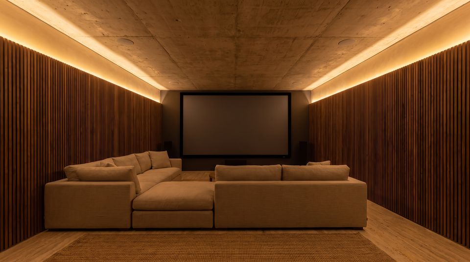 Sala de cine en casa con parlantes empotrados en el cielo raso de hormigón